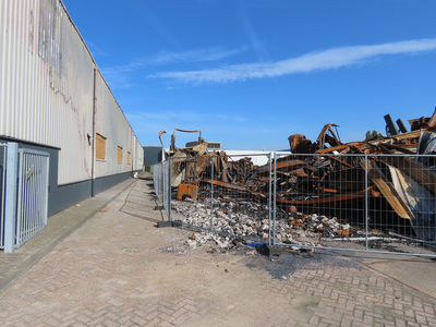 912107 Gezicht op de verwrongen metalen restanten van het uitgebrande bedrijfsverzamelgebouw Strijkviertel 35 te De ...